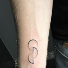 a man's arm with a tattoo on it that has the letter b in black ink