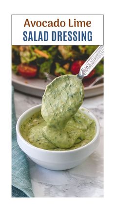 avocado lime salad dressing in a white bowl with a spoon sticking out of it