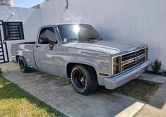 an older pickup truck parked in front of a house