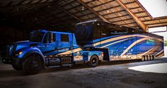 two semi trucks parked next to each other in a garage with a roof over them