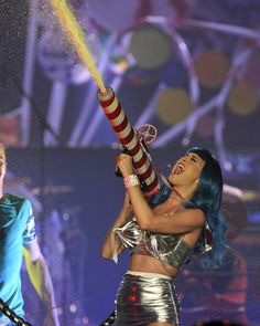 a woman with blue hair holding a fire extinguisher