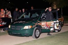 a group of people standing next to a green van with an eagle painted on it