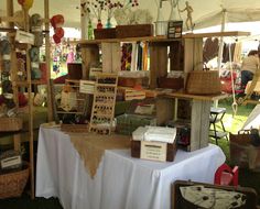 an outdoor flea market with baskets and other items on the table in front of it