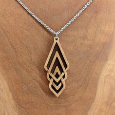 This triple diamond pendant is hand carved from maple, cherry, or walnut wood. Lightweight and ideal for daily wearing. 18" black or silver stainless steel chain included. The triple diamond measures approximately 2.5” tall x 1.0” wide. The item ordered comes in a cute gift bag. Items shown in the gift bag in the photo are for illustrative purposes. Free shipping for US customers. Every piece of wood is naturally different, the grain in your jewelry may differ slightly from the wood in the photo Monogram Wood Necklace, Wood Necklace Pendant, Wood Jewelery, Bag Items, Dremel Wood Carving, Wood Carving Designs, Wood Carving Patterns, Carving Designs, Wood Necklace