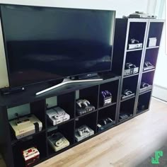 a flat screen tv sitting on top of a black shelf