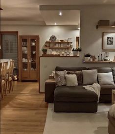 a living room filled with furniture next to a kitchen