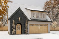 a house with two garages and snow on the ground