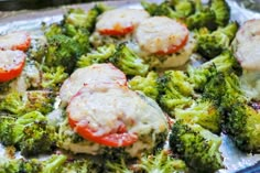 broccoli with tomatoes and meat on it in a baking pan, ready to be cooked