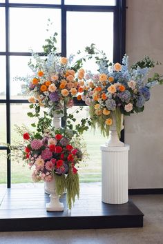 two white vases filled with different colored flowers