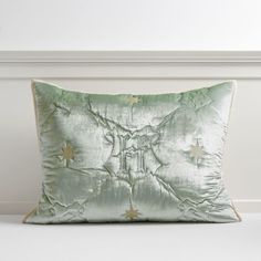 a green pillow with gold stars on the side and a white wall in the background