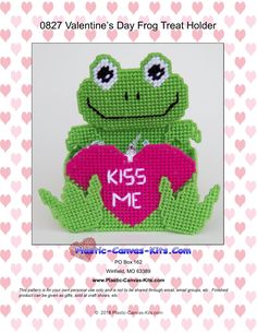 a cross stitch frog holding a heart with the words kiss me on it's chest