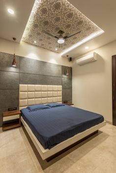 a large bed sitting under a ceiling fan in a bedroom next to a wall mounted air conditioner