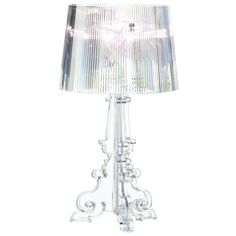 a glass table lamp with a clear shade on it's base and an intricate design