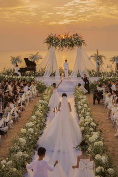 the bride and groom are walking down the aisle to their wedding ceremony on the beach