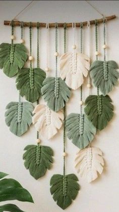 a green and white wall hanging with leaves