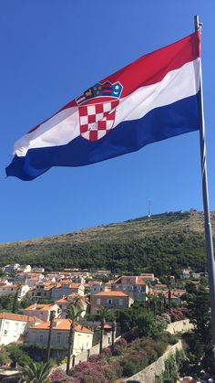 a flag flying in the wind over a small town