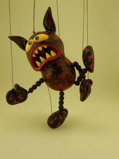 a toy that looks like a monster hanging from strings with it's mouth open