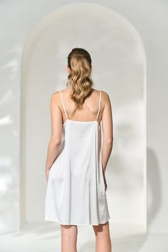 Our soft and luxurious, yet simple, slip dress is a staple piece for every girl's wardrobe. This piece was designed for our brides and bridal parties to wear under their By Catalfo robes (available in lace, solid colours or floral prints). Made in a lightweight, flowy charmeuse with adjustable shoulder straps, this will definitely be a staple piece in your wardrobe for years to come. Material: Soft, silk-like charmeuseShoulder Straps: Adjustable shoulder strapsFit: A-line and flowy Styling Layer White V-neck Slip Dress With Delicate Straps, V-neck Slip Dress With Delicate Straps For Wedding, Sheer V-neck Slip Dress For Wedding Night, Camisole Sleep Dress With Delicate Lace, Elegant Dresses With Built-in Bra For Daywear, Elegant Midi Dress With Adjustable Straps For Wedding, Feminine Sheer Dresses For Loungewear, Feminine Sheer Lounge Dress, Feminine Sheer Loungewear Dress