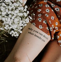 a woman with a tattoo on her arm holding a bouquet of flowers and the words, my you can decide what breaks you