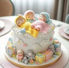 there is a cake that has two babies on it and some teddy bears in the middle