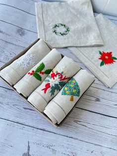 three christmas napkins in a box on a wooden table