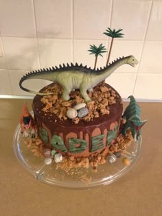 a dinosaur cake on top of a clear plate