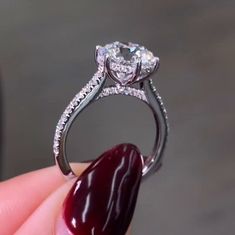 a close up of a person holding a diamond ring