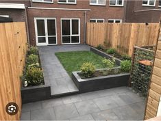 a small backyard garden with wooden fenced in area