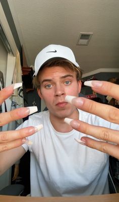 a young man is holding out his hands to show off the white substance on his fingers