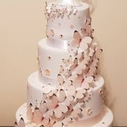 a three tiered white wedding cake with butterflies on it