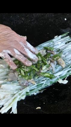 a person in gloves is washing vegetables on a grill