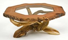 a table made out of wood with a glass top on it's legs and branches