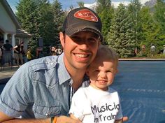 a man and his son are posing for a photo in front of a pool with trees