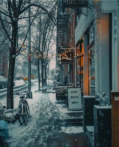 a snowy street lined with parked bicycles and buildings