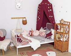 a small child's bed in a room with pink and white decor on the walls