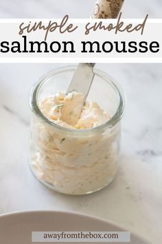 a jar filled with mayonnaise sitting on top of a white counter next to a plate