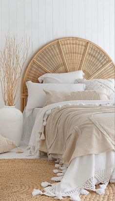 a wicker headboard with white linens and pillows in a neutral bedroom setting