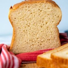 a loaf of bread sitting on top of a table next to some slices of bread