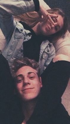 two people laying on the floor with their arms around each other and one person holding his head