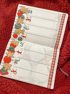 an open notebook with stickers on the cover and writing paper attached to it, sitting on a red blanket