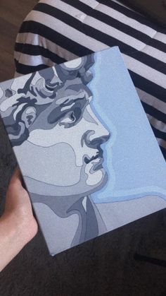 a person holding a box with a painting on it