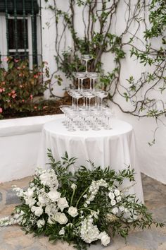 a table with wine glasses and flowers on it