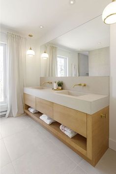 a bathroom with two sinks and a large mirror in it's center area,