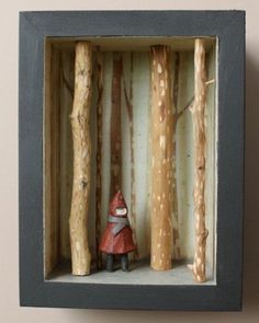 there is a small figurine in a box with some trees around it and a gnome