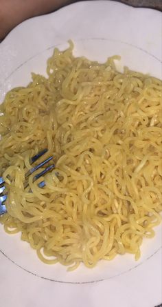 a white plate topped with noodles and two forks