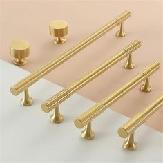 four golden handles and two knobs on a pink background