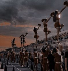 a group of cheerleaders performing stunts in front of a crowd