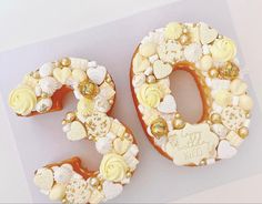 a cake shaped like the number 50 with flowers and pearls on it's sides