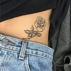 a woman's stomach with a rose tattoo on her lower body and the bottom part of her stomach