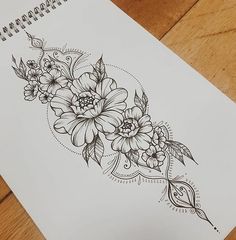 a drawing of some flowers on a piece of paper with pen and ink next to it